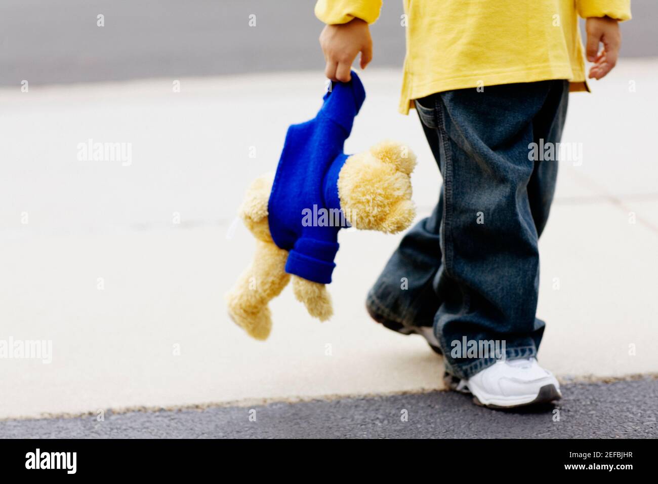 Vista in sezione bassa di un ragazzo che tiene un orsacchiotto Foto Stock