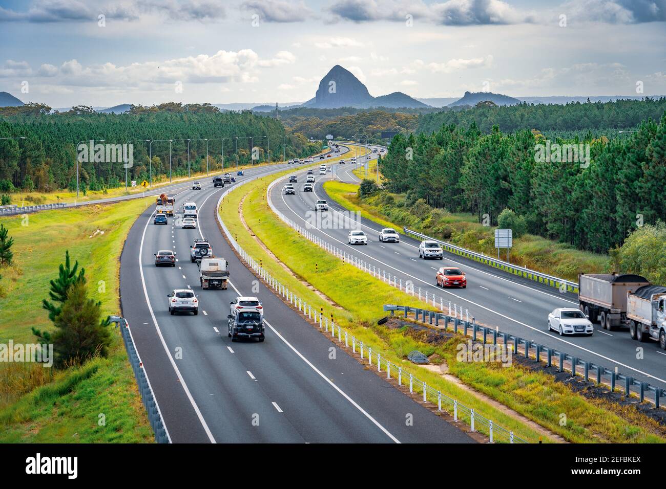 Queensland, Australia - Auto che si muovono lungo Bruce Hwy con le montagne Glass House sullo sfondo Foto Stock