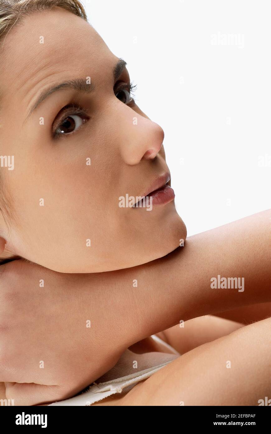 Close-up di una giovane donna con le mani dietro la testa Foto Stock