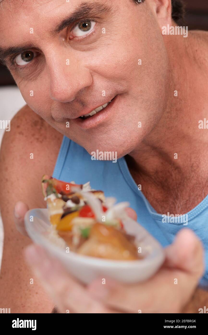 Ritratto di un uomo maturo che tiene una crostata e sorridente Foto Stock