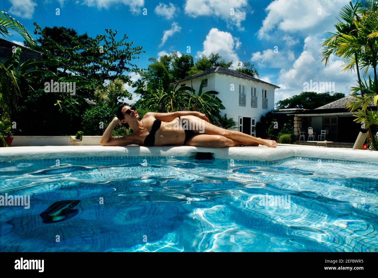 Donna che si rilassa vicino ad una piscina al Bon Vivant Villa sull'isola di Giamaica Foto Stock