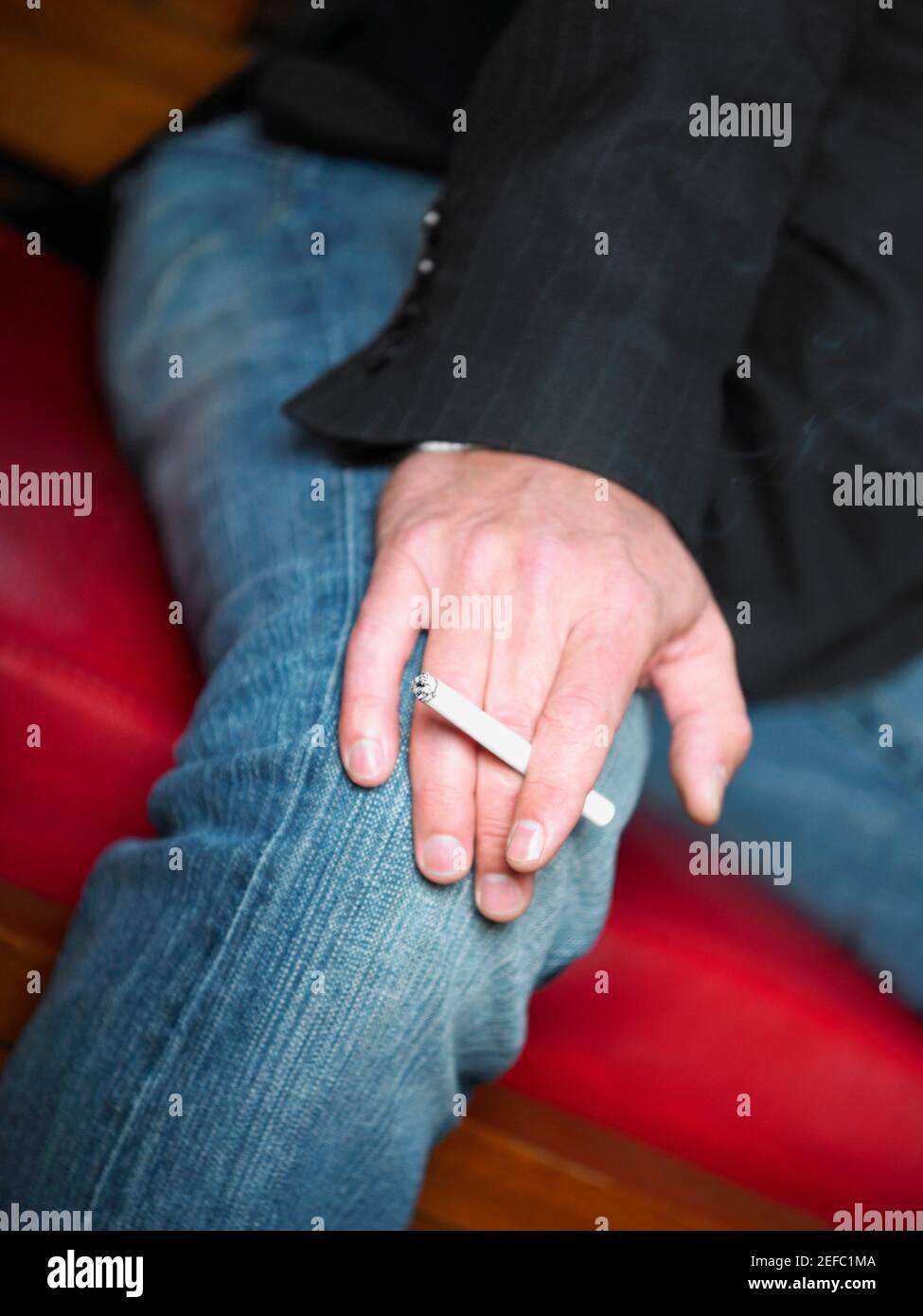 Vista in sezione intermedia di un uomo che tiene una sigaretta Foto Stock