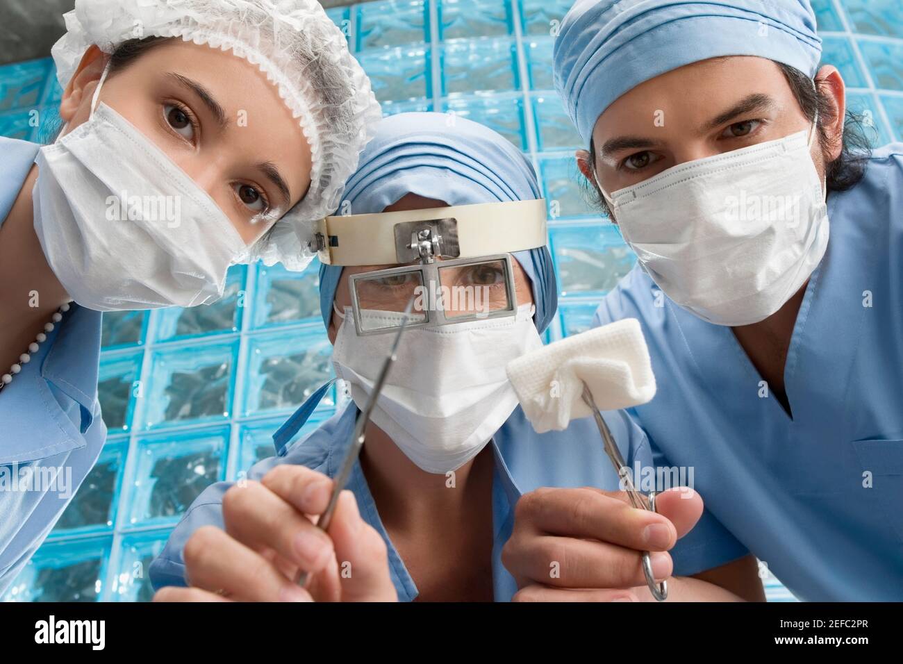 Due chirurghi maschi e un chirurgo maschile in un operatorio camera Foto Stock