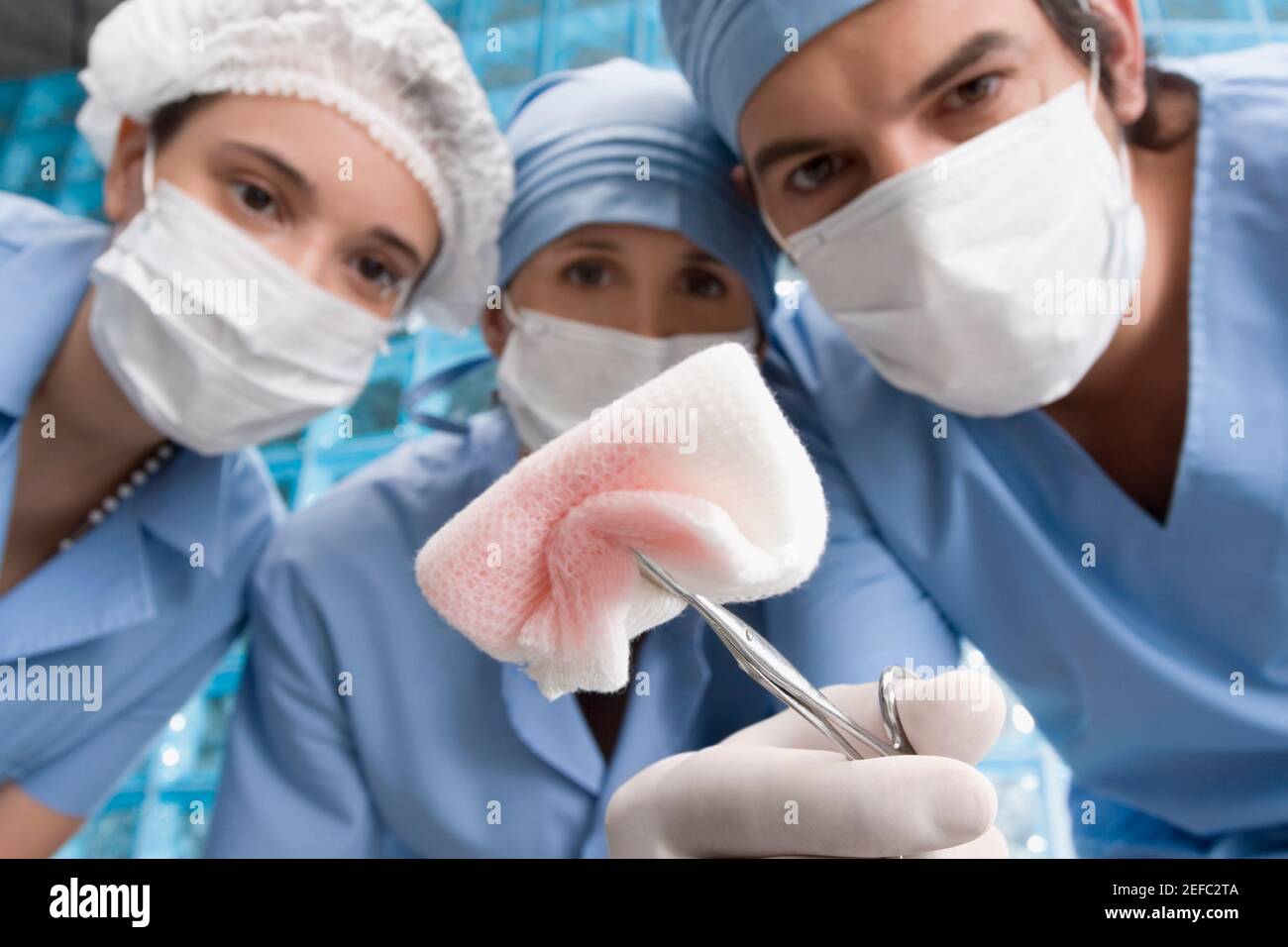 Due chirurghi femminili e un chirurgo maschile in un operatorio camera Foto Stock
