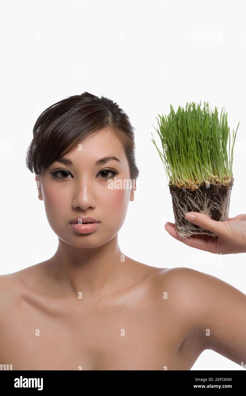 Ritratto di una giovane donna che regge il wheatgrass Foto Stock