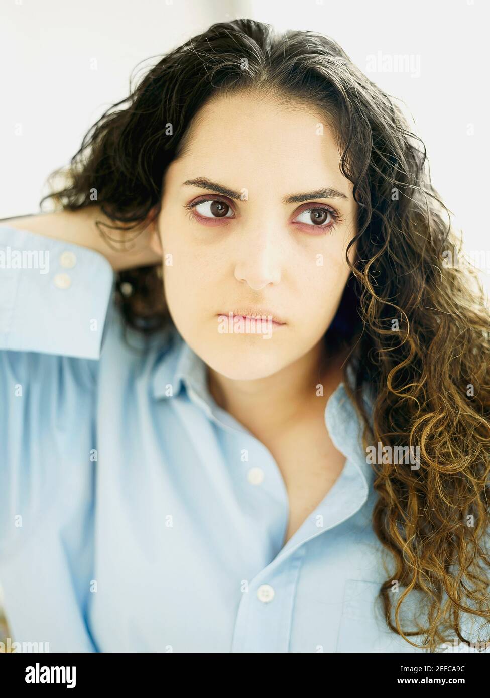 Primo piano di una giovane donna con la mano in lei capelli Foto Stock