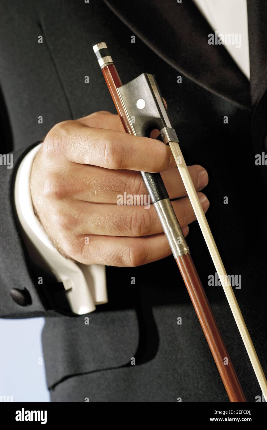 Vista in sezione intermedia di un musicista che tiene l'arco di un violino Foto Stock