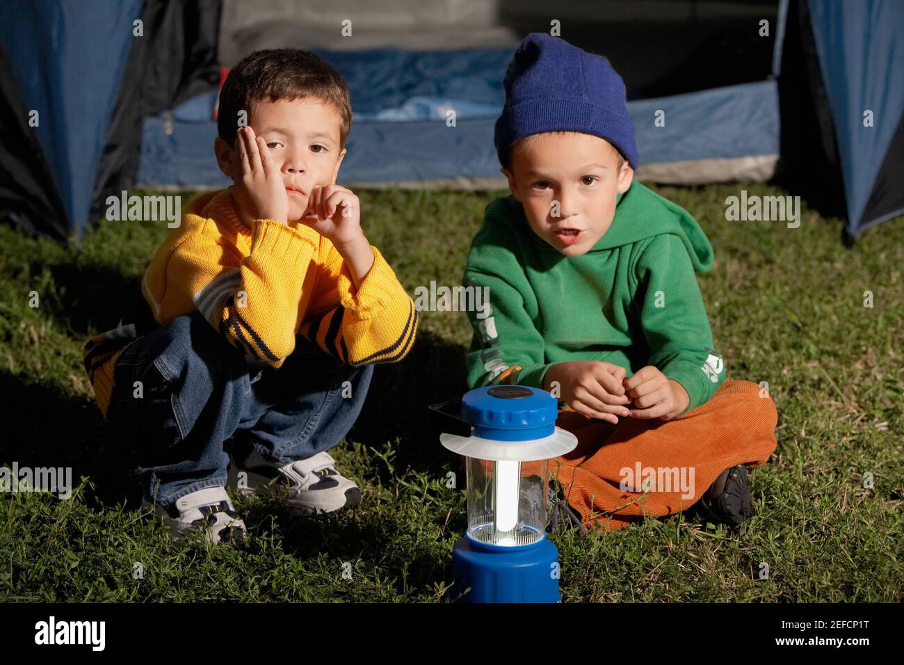 Ritratto di due ragazzi seduti insieme di fronte a un tenda Foto Stock