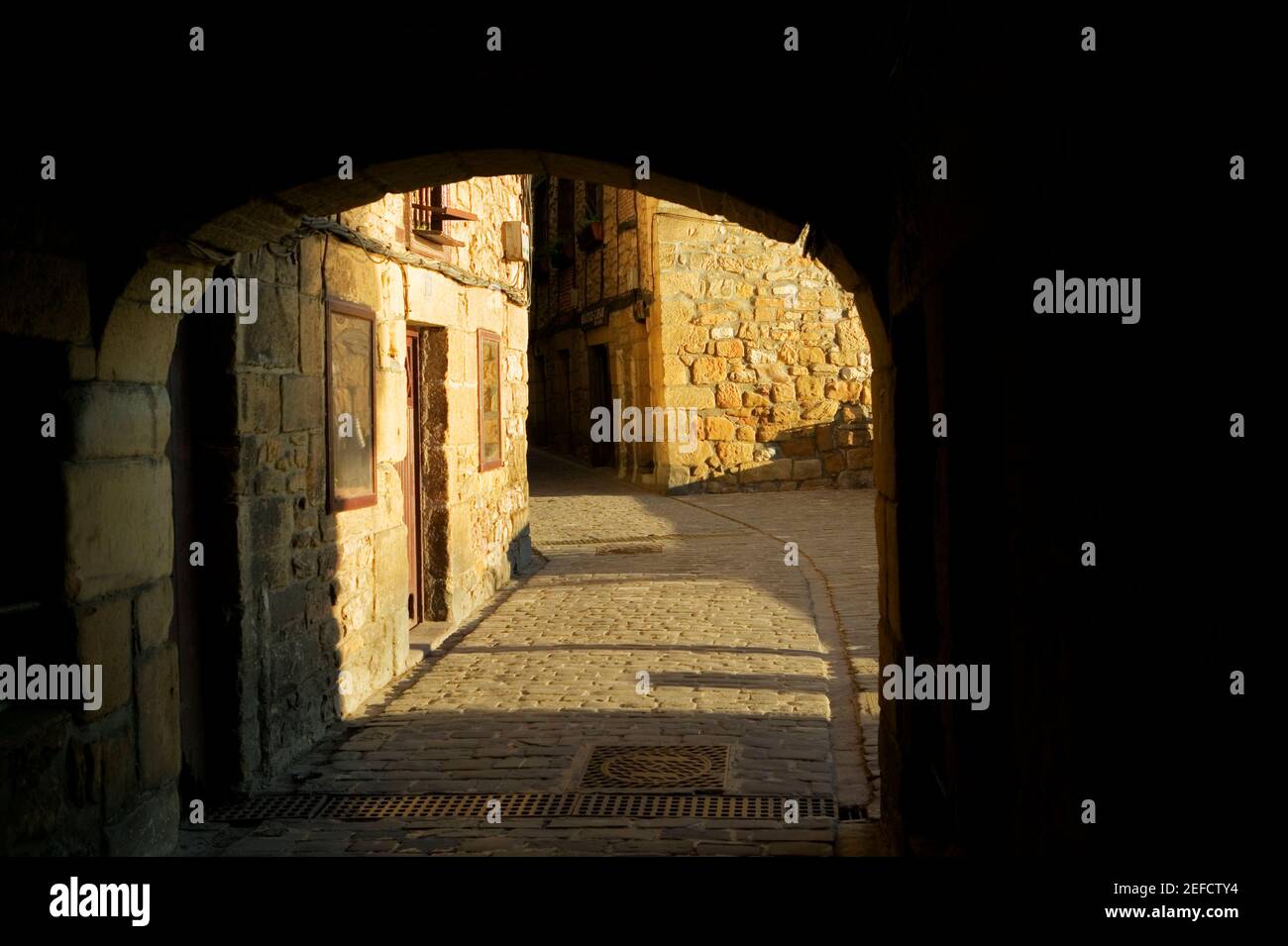 Porta ad arco che conduce ad un vicolo di ciottoli, Spagna Foto Stock