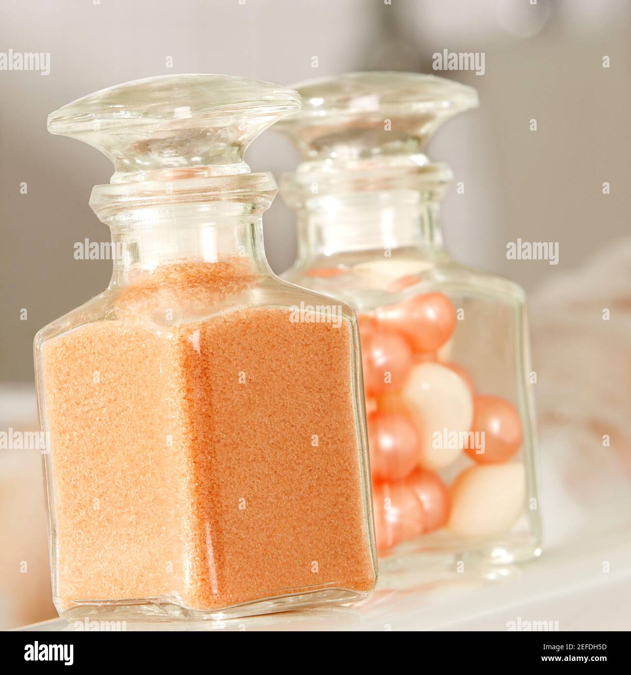 Primo piano di una polvere da bagno e perle da bagno in vetro bottiglie Foto Stock