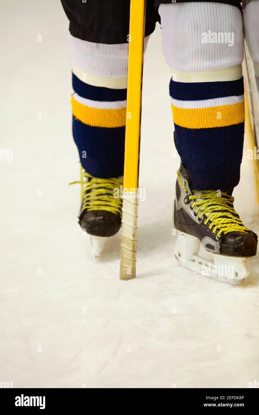 Vista in sezione bassa di un giocatore di hockey su ghiaccio con un bastone per hockey su ghiaccio Foto Stock