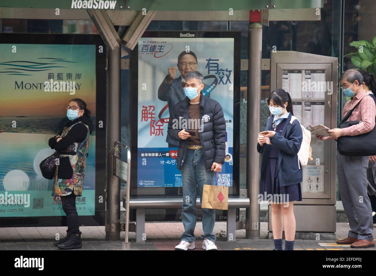 2021 gennaio 22, Hong Kong. Durante l'epidemia, i cittadini che indossano maschere sono in attesa per l'autobus Foto Stock