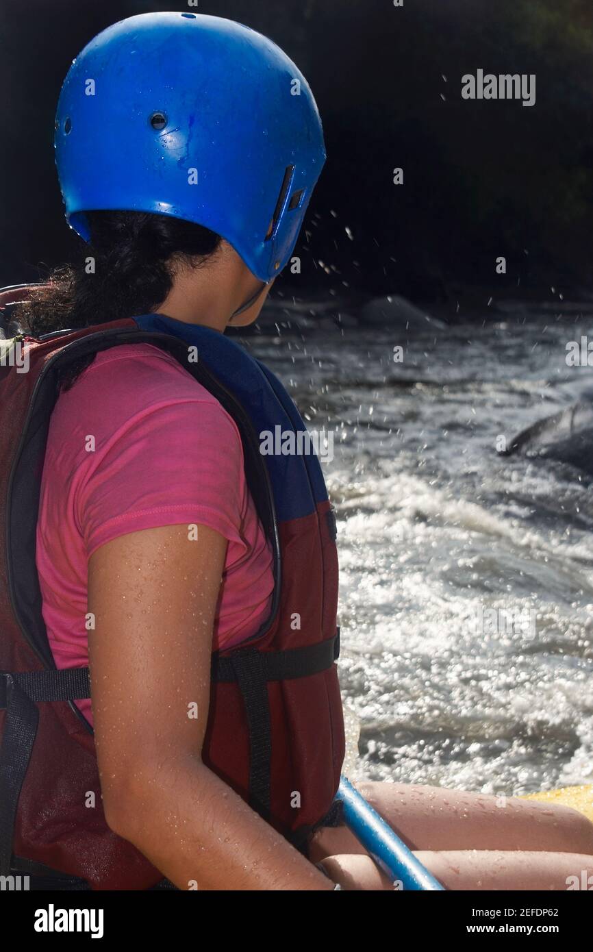 Profilo laterale di una donna che rafting in un fiume Foto Stock