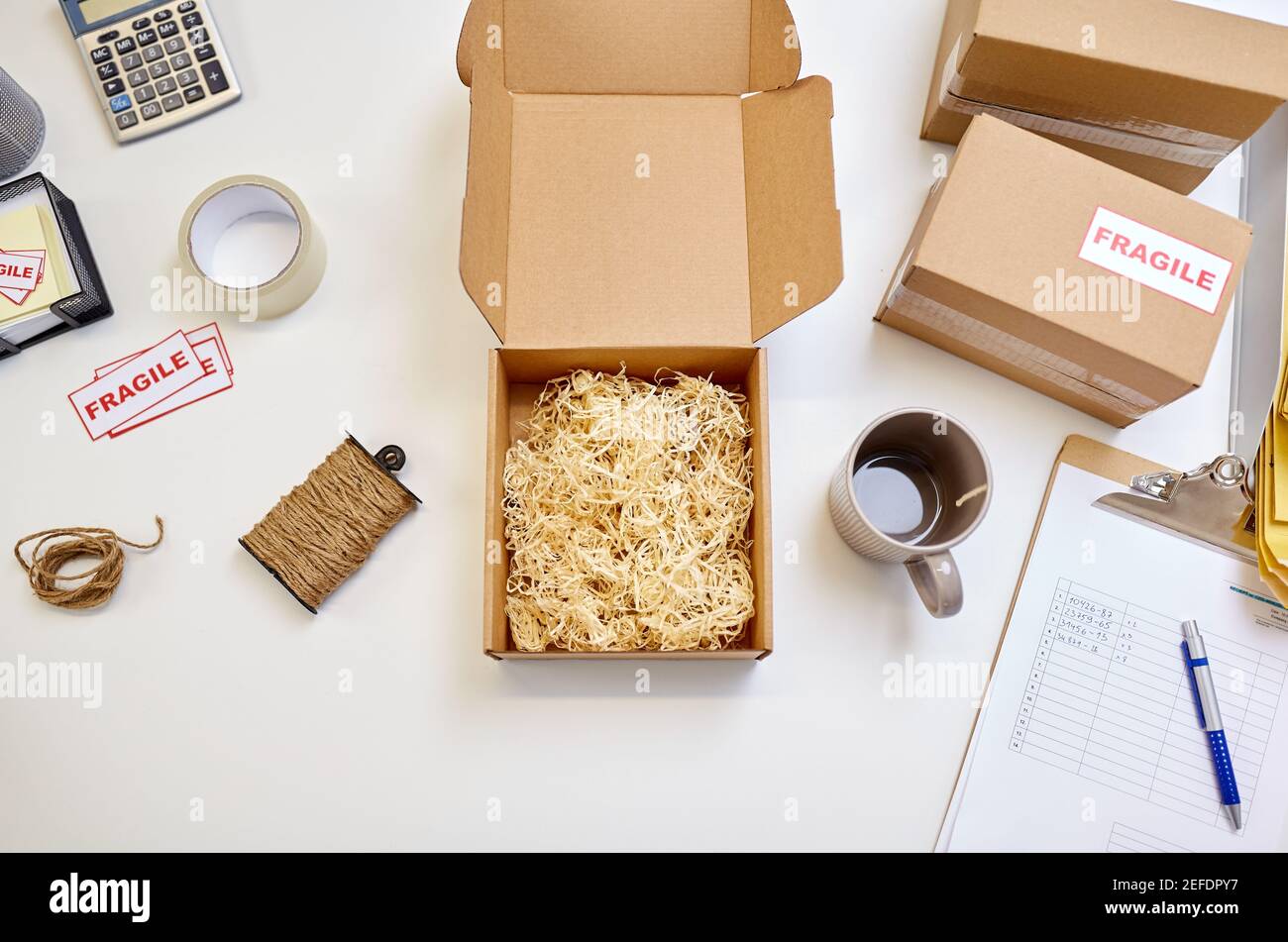 pacco con riempitivo paglia e tazza presso l'ufficio postale Foto Stock