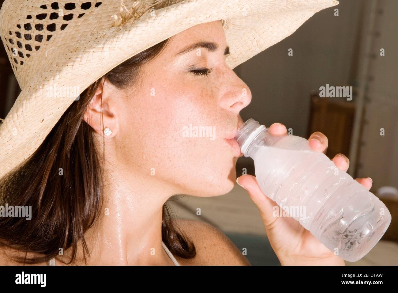 Close-up di una giovane donna di bere acqua da una bottiglia Foto Stock
