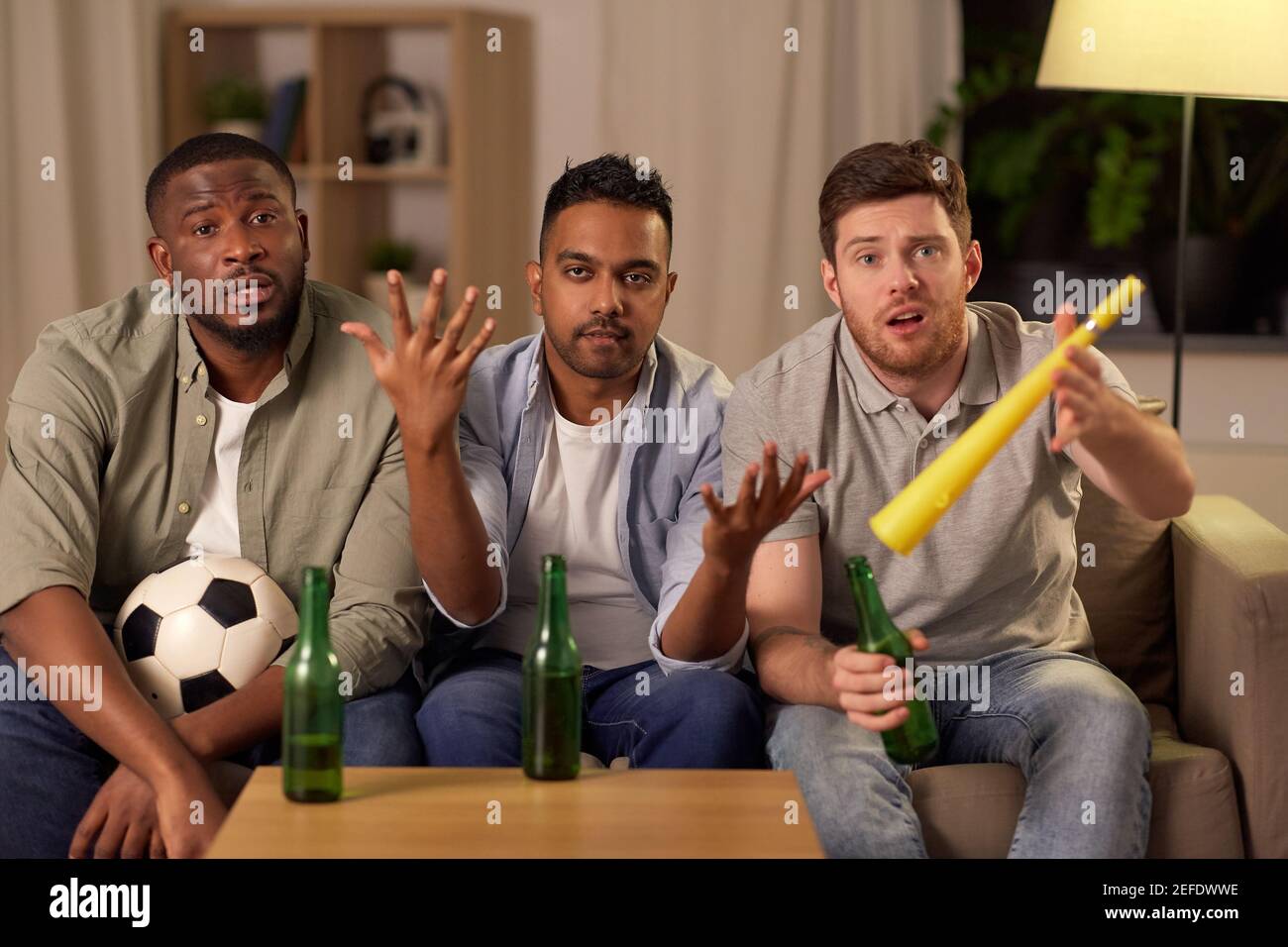 amici maschi tristi o tifosi di calcio con birra a casa Foto Stock