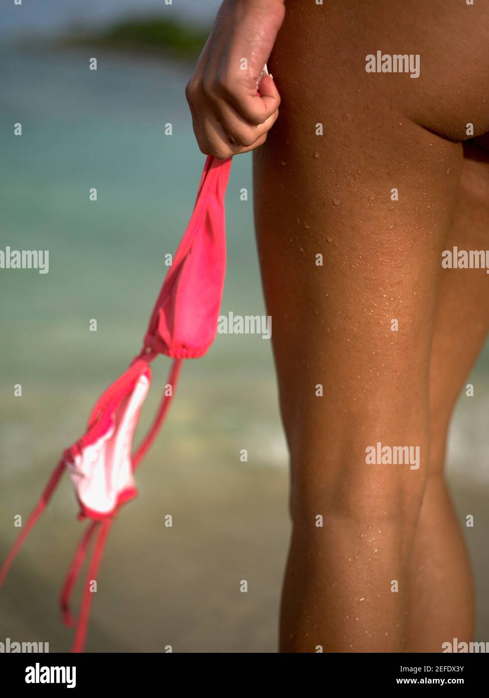 Vista in sezione centrale di una donna che tiene un bikini top Foto Stock