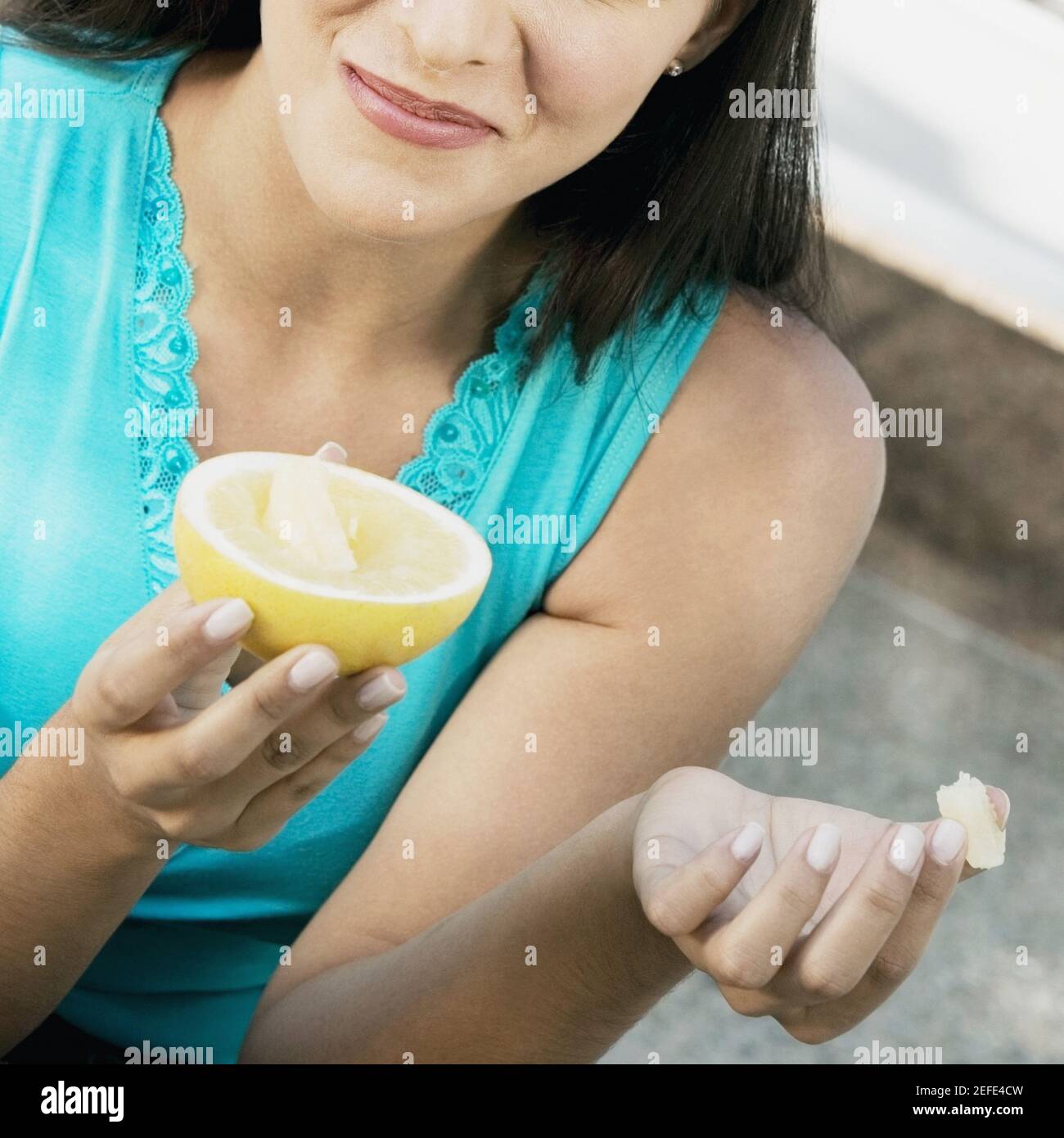 Primo piano di una giovane donna che tiene mezzo calce e. sorridente Foto Stock