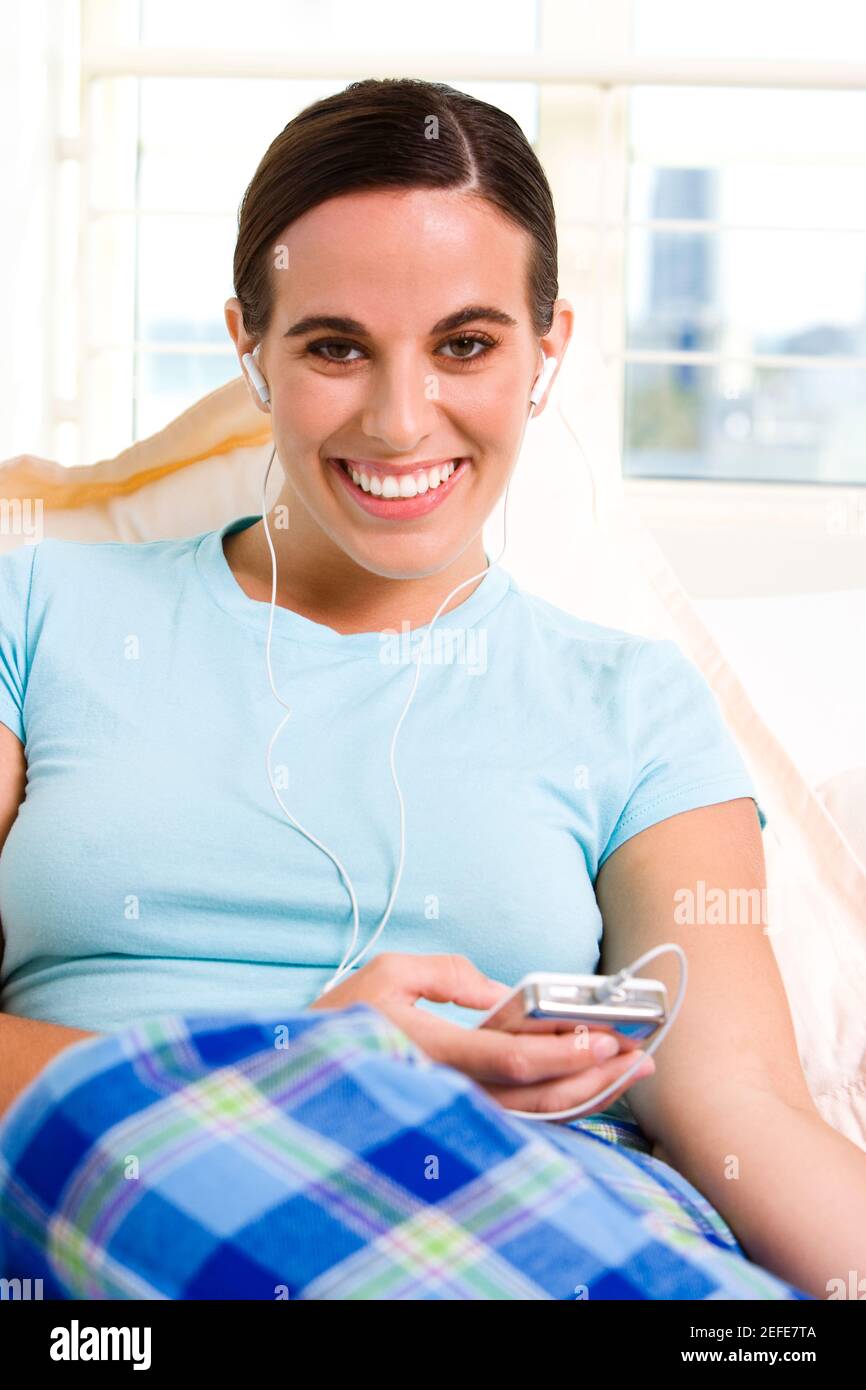 Ritratto di una giovane donna di ascolto di un lettore MP3 Foto Stock