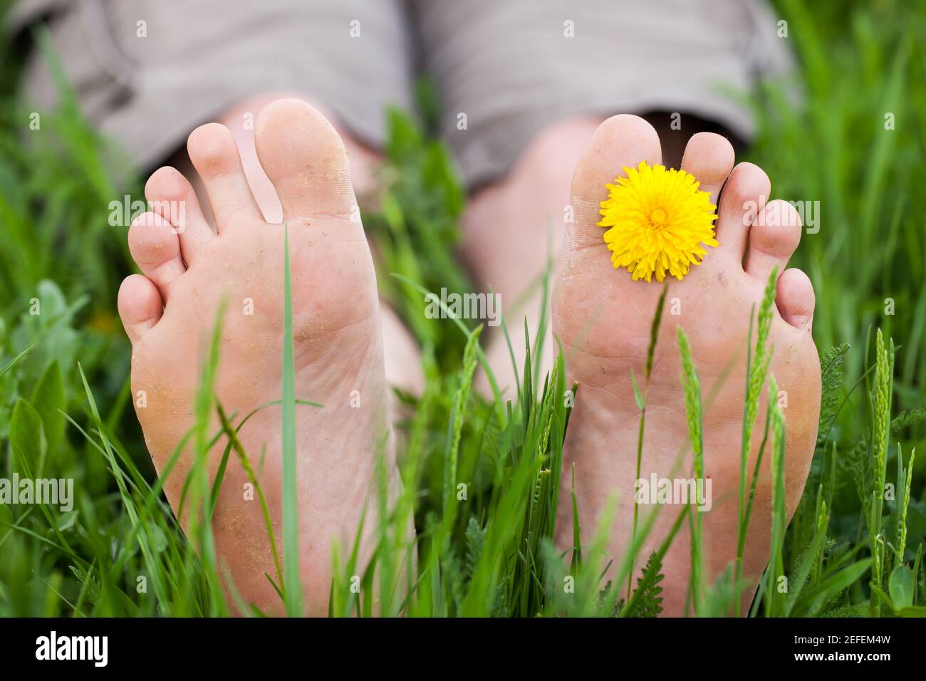 Steso a piedi nudi nell'erba alta Foto Stock