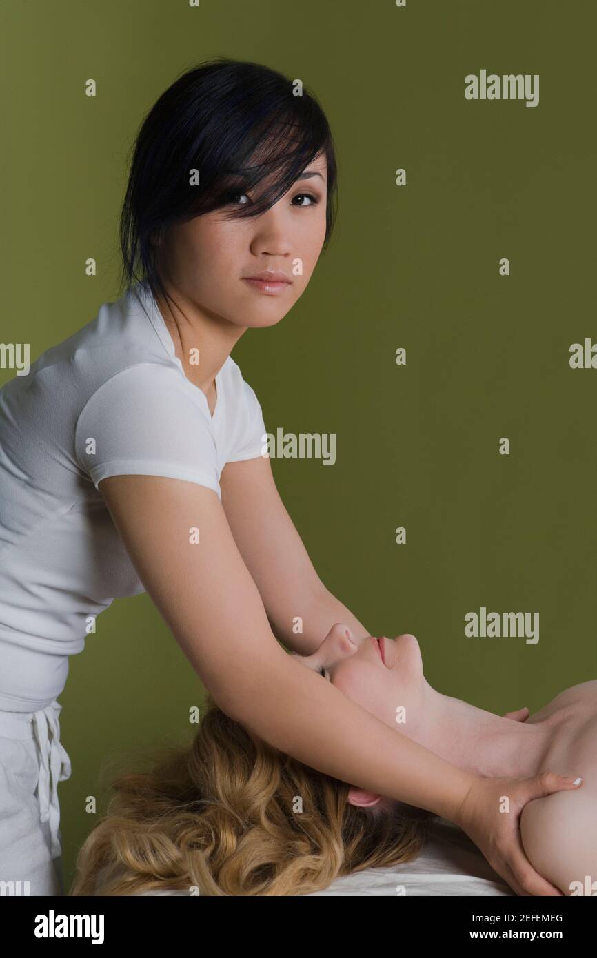 Profilo laterale di una donna matura che riceve un massaggio alle spalle da un massaggiatore Foto Stock