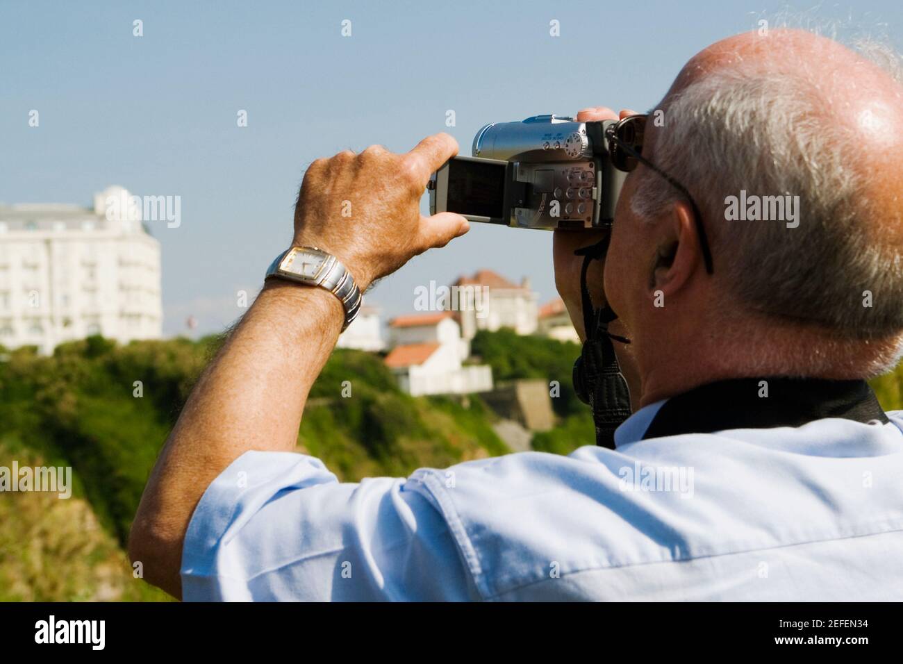 Vista posteriore di un uomo che filma con la sua videocamera domestica, Biarritz, Paesi Baschi, Pirenei Atlantici, Aquitania, Francia Foto Stock