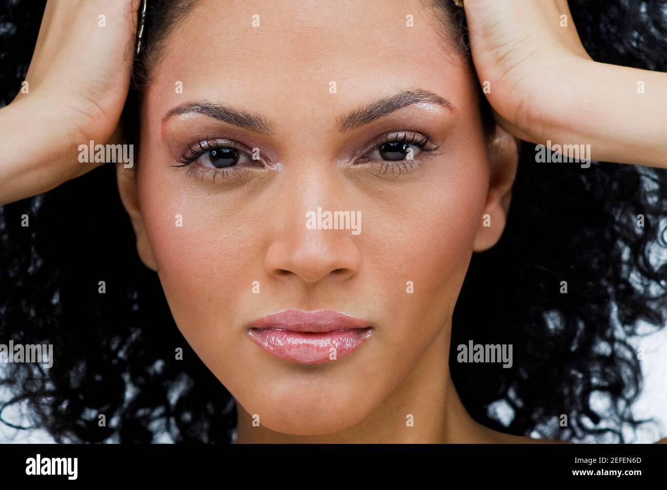 Ritratto di una giovane donna con la sua testa con le mani Foto Stock