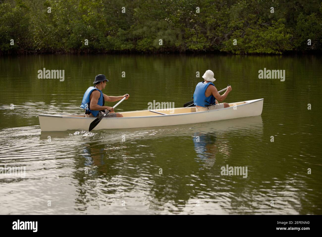 Profilo laterale di due uomini medio adulti in canoa Foto Stock