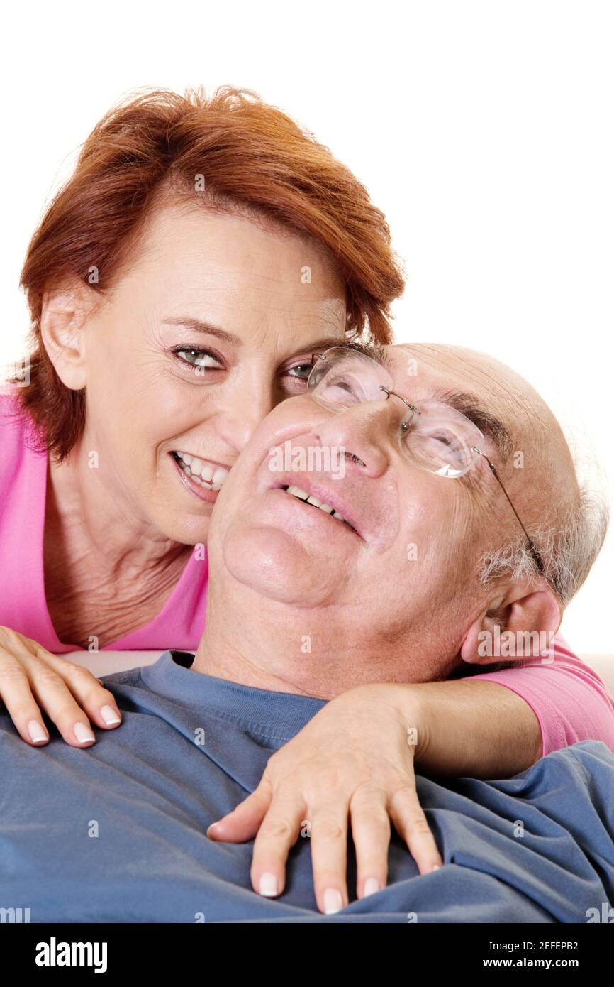 Ritratto di una donna anziana che abbraccia un uomo anziano da dietro Foto Stock