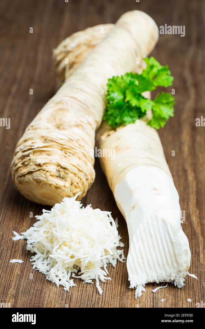 Due radici di rafano su una tavola di legno Foto Stock