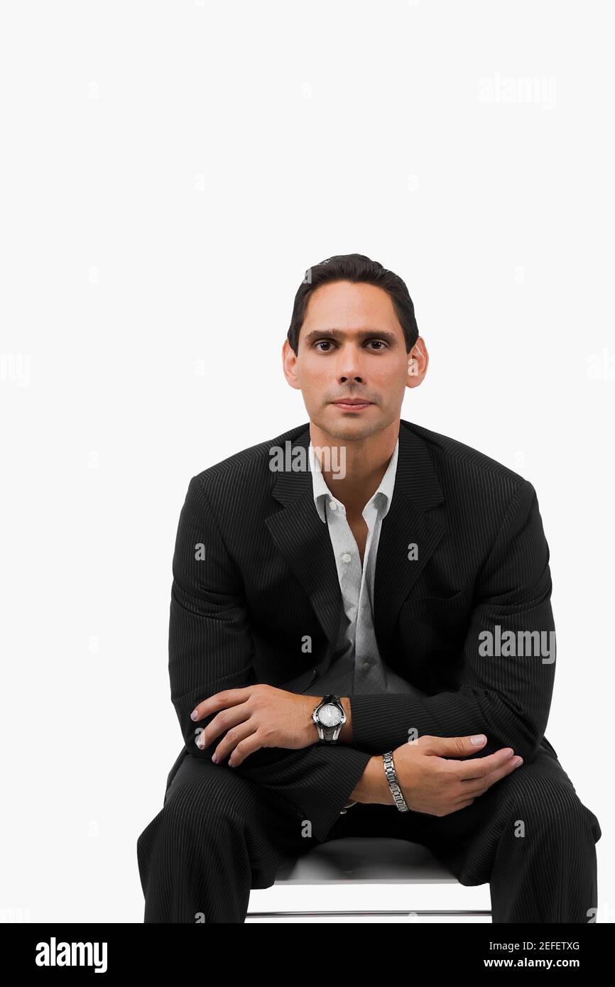Ritratto di un uomo d'affari seduto con le braccia incrociate Foto Stock