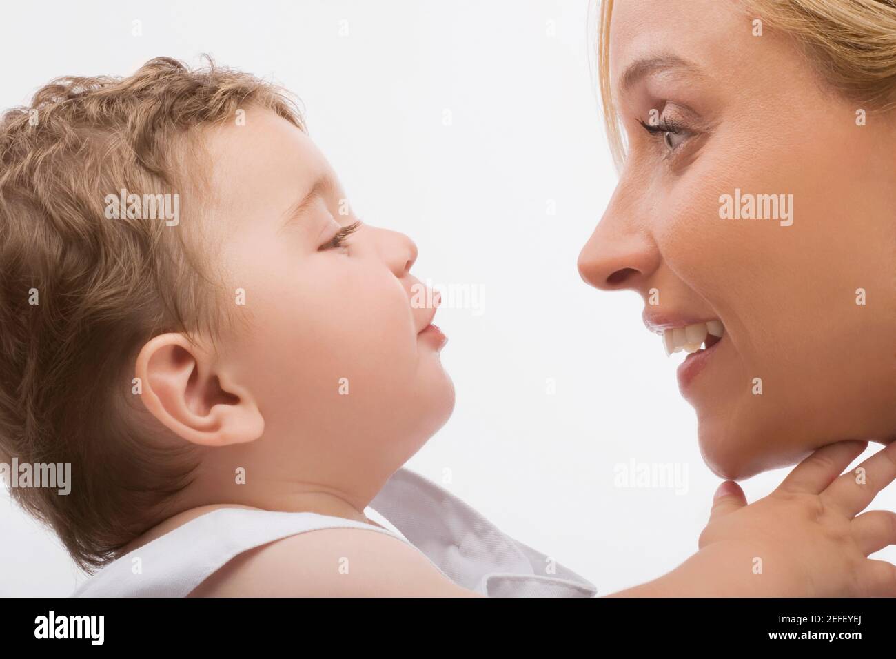 Primo piano di una donna mid adulta che guarda suo figlio e sorridendo Foto Stock