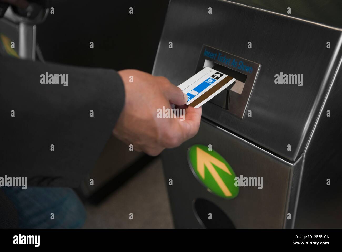 Close up di una mano di manÅ½s che controlla il suo biglietto in un macchina di check-in Foto Stock