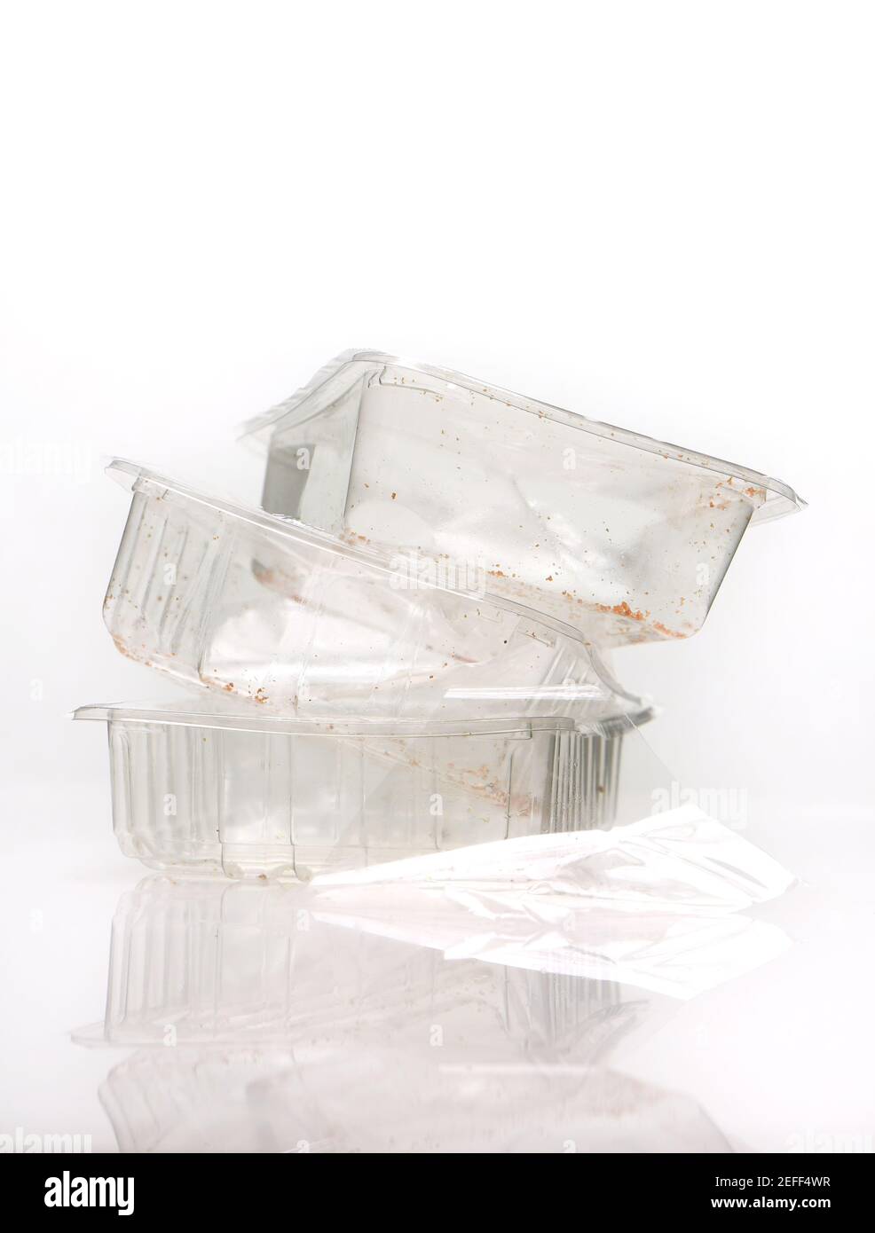 I vassoi di cibo usati sparati su uno sfondo bianco con riflessione, molti contenitori di raccolta domestica del consiglio non possono trattare i vassoi di cibo di plastica. Foto Stock