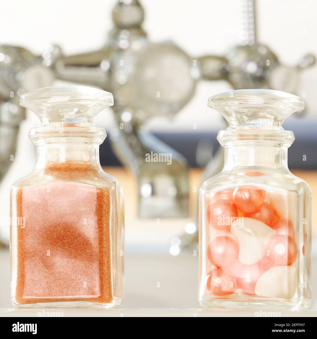 Primo piano di polvere di sapone e perle da bagno in bottiglie di vetro Foto Stock