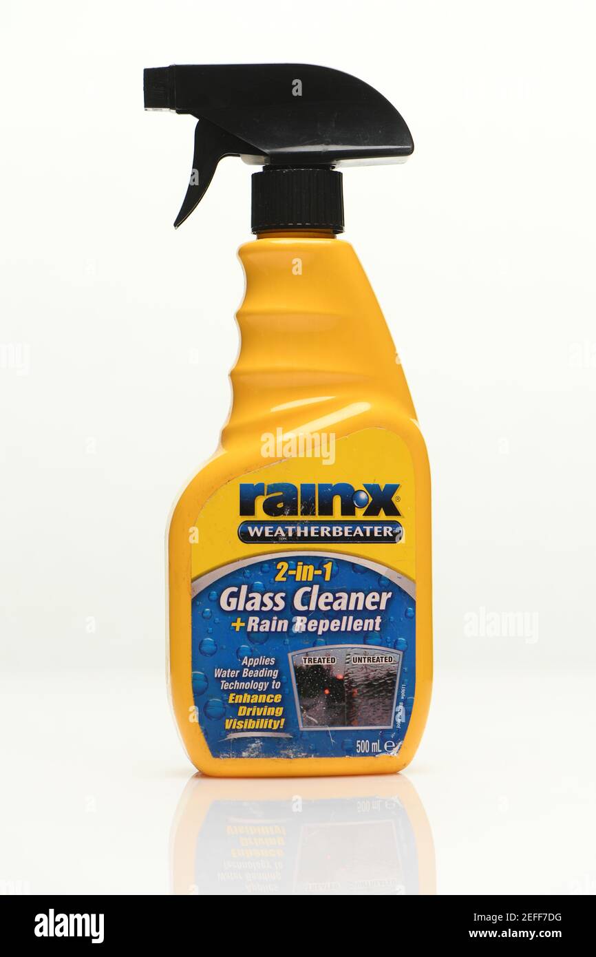 Rainx Glass e detergente repellente per parabrezza auto sparati su uno sfondo bianco con un riflesso. Foto Stock