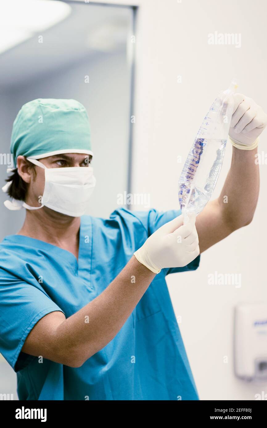 Chirurgo maschile che tiene un sacchetto fleboclisi per infusione endovenosa Foto Stock