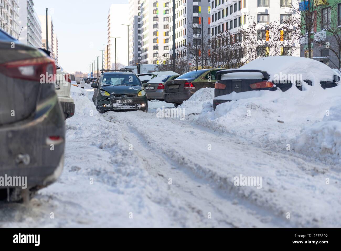 Mosca. Russia. Nevicate nel mese di febbraio. Vialetti in iarde dopo una nevicata. In città dopo una nevicata, le ruote si rovinano. Le conseguenze dopo una storia Foto Stock