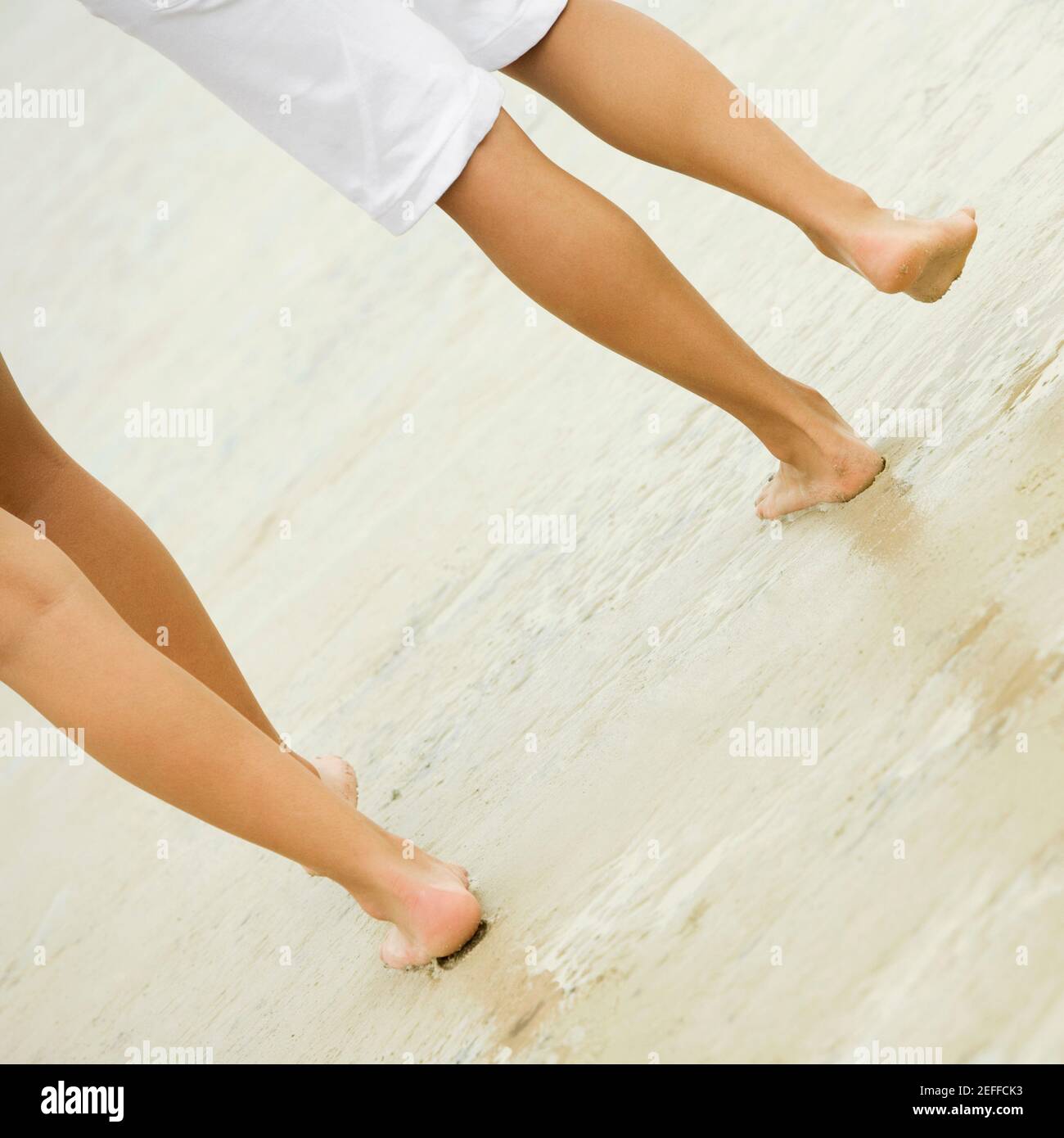 Bassa vista in sezione di due persone di camminare sulla spiaggia Foto Stock