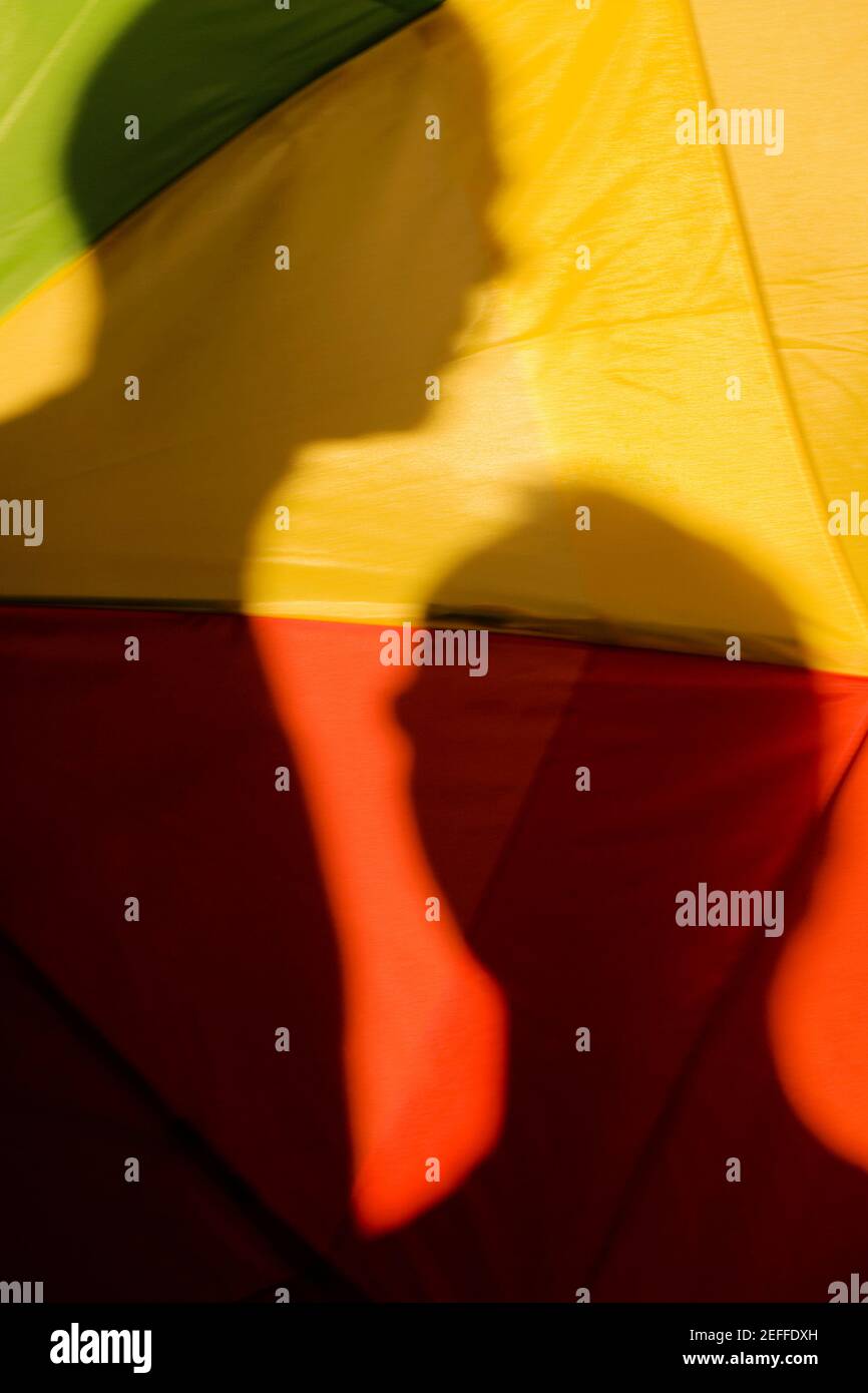 Primo piano dell'ombra di due persone su un gay bandiera dell'orgoglio Foto Stock