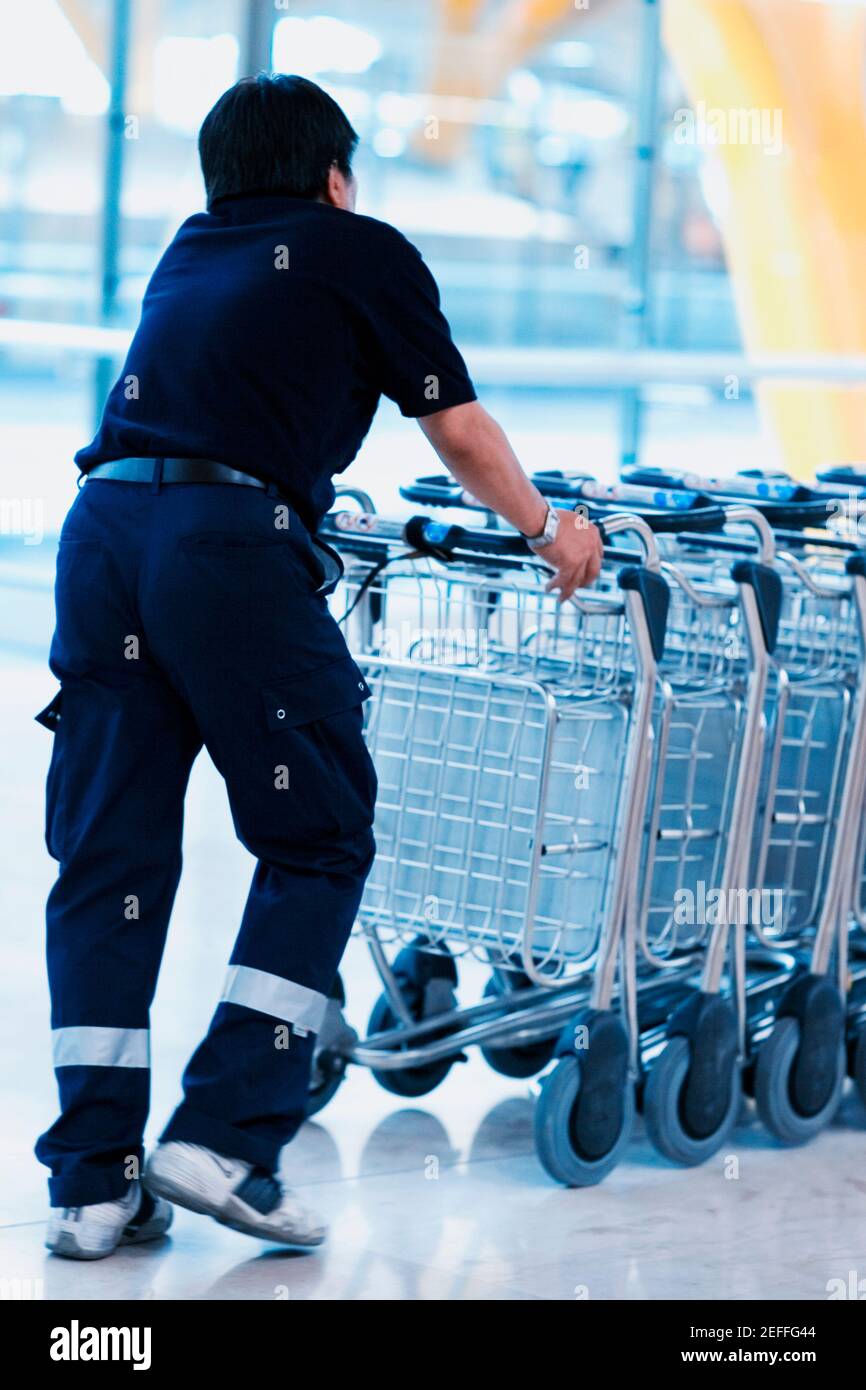 Vista posteriore di una persona che spinge i carrelli bagagli in fila, Madrid, Spagna Foto Stock