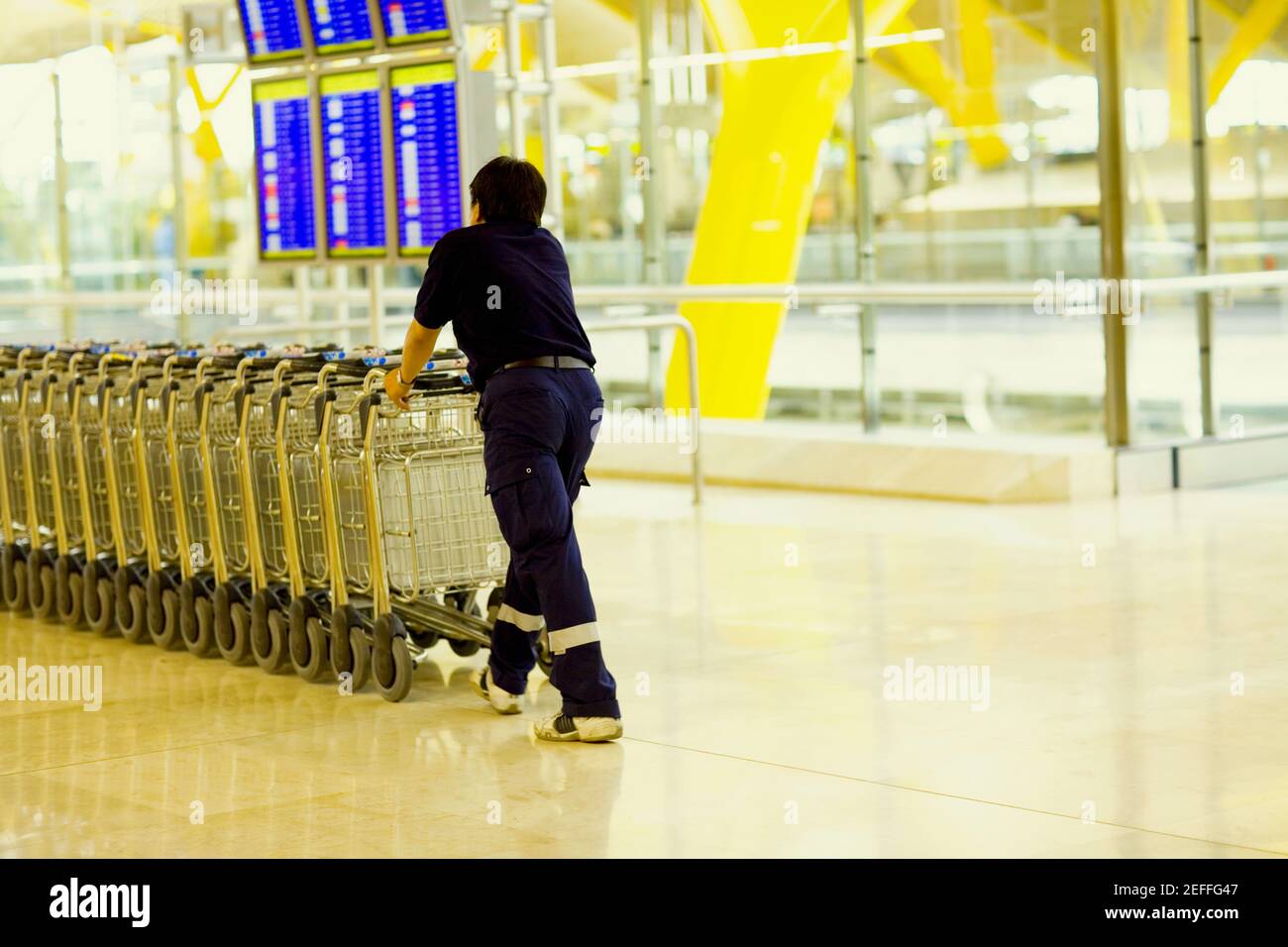 Vista posteriore di una persona che spinge i carrelli bagagli in fila, Madrid, Spagna Foto Stock