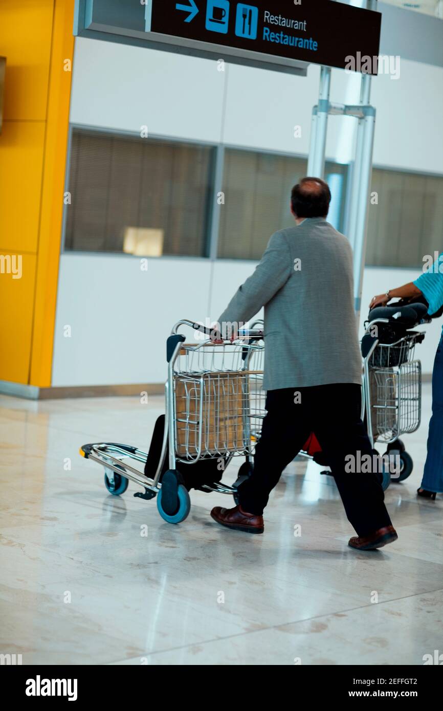 Profilo laterale di una persona che spinge un carrello di bagagli, Madrid, Spagna Foto Stock