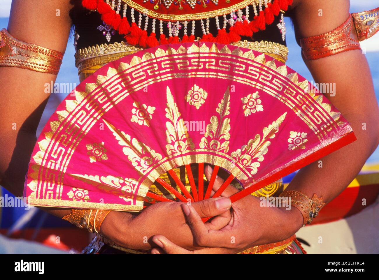 Vista in sezione centrale di una donna che tiene un ventilatore pieghevole, Bali, Indonesia Foto Stock