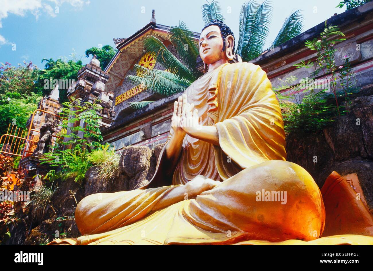 Vista ad angolo basso di una statua di Buddha di fronte ad un edificio, Bali, Indonesia Foto Stock