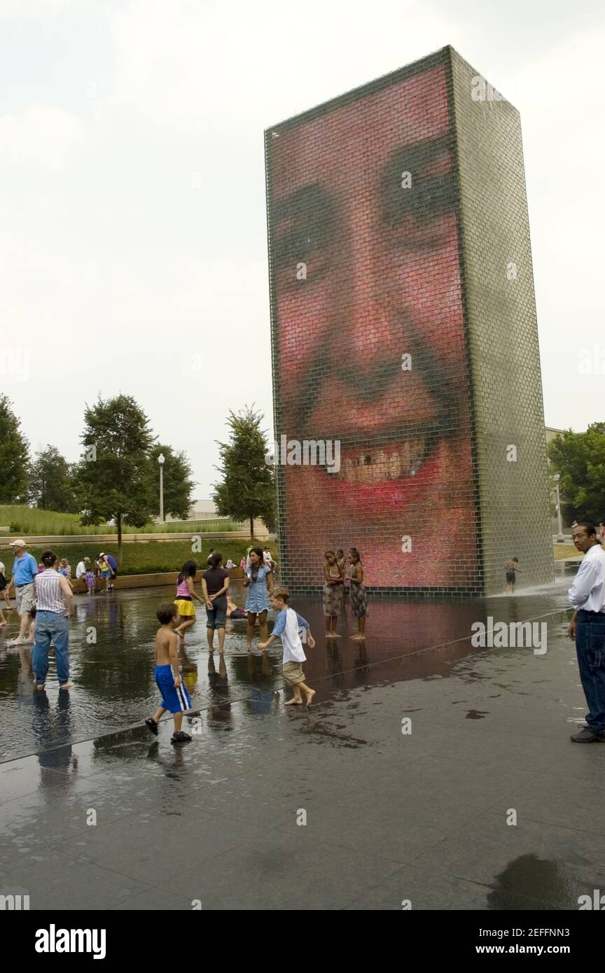 Turisti che si trovano di fronte a una fontana, Crown Fountain, Millennium Park, Chicago, Illinois, STATI UNITI Foto Stock