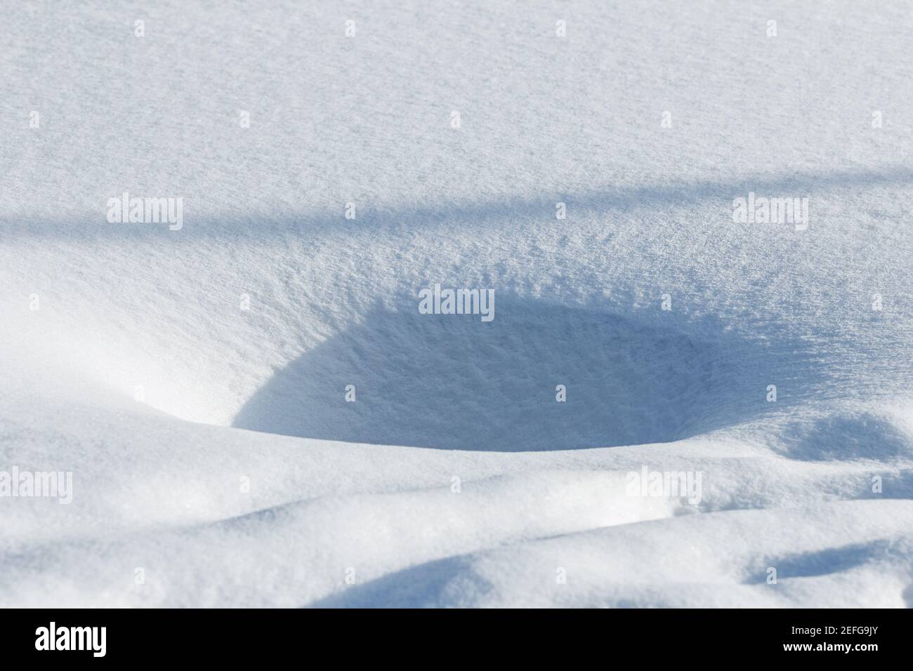 Vera buca nella neve limpida nella soleggiata giornata invernale felice Foto Stock