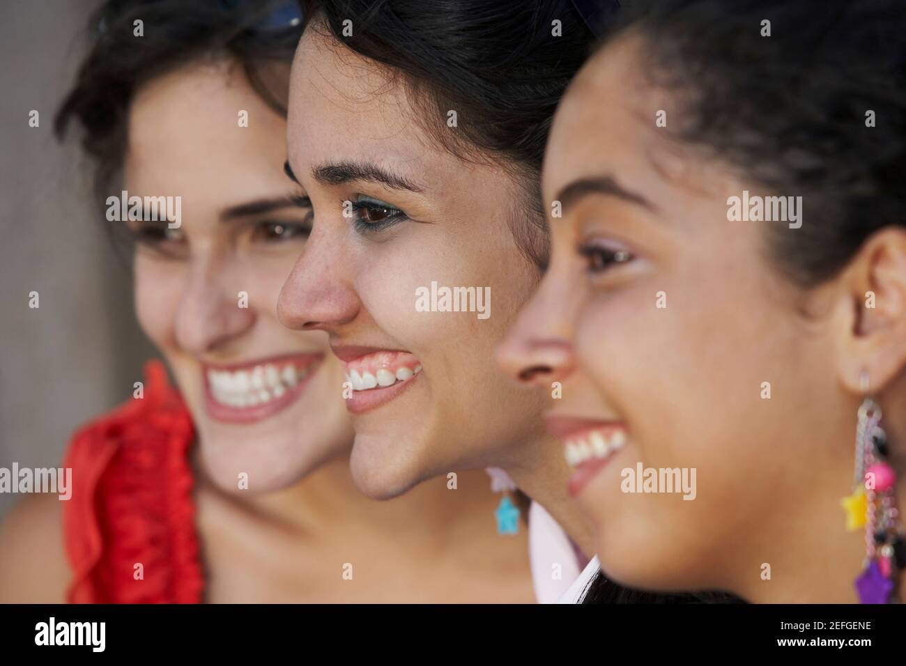 Close-up di tre giovani donne sorridente Foto Stock
