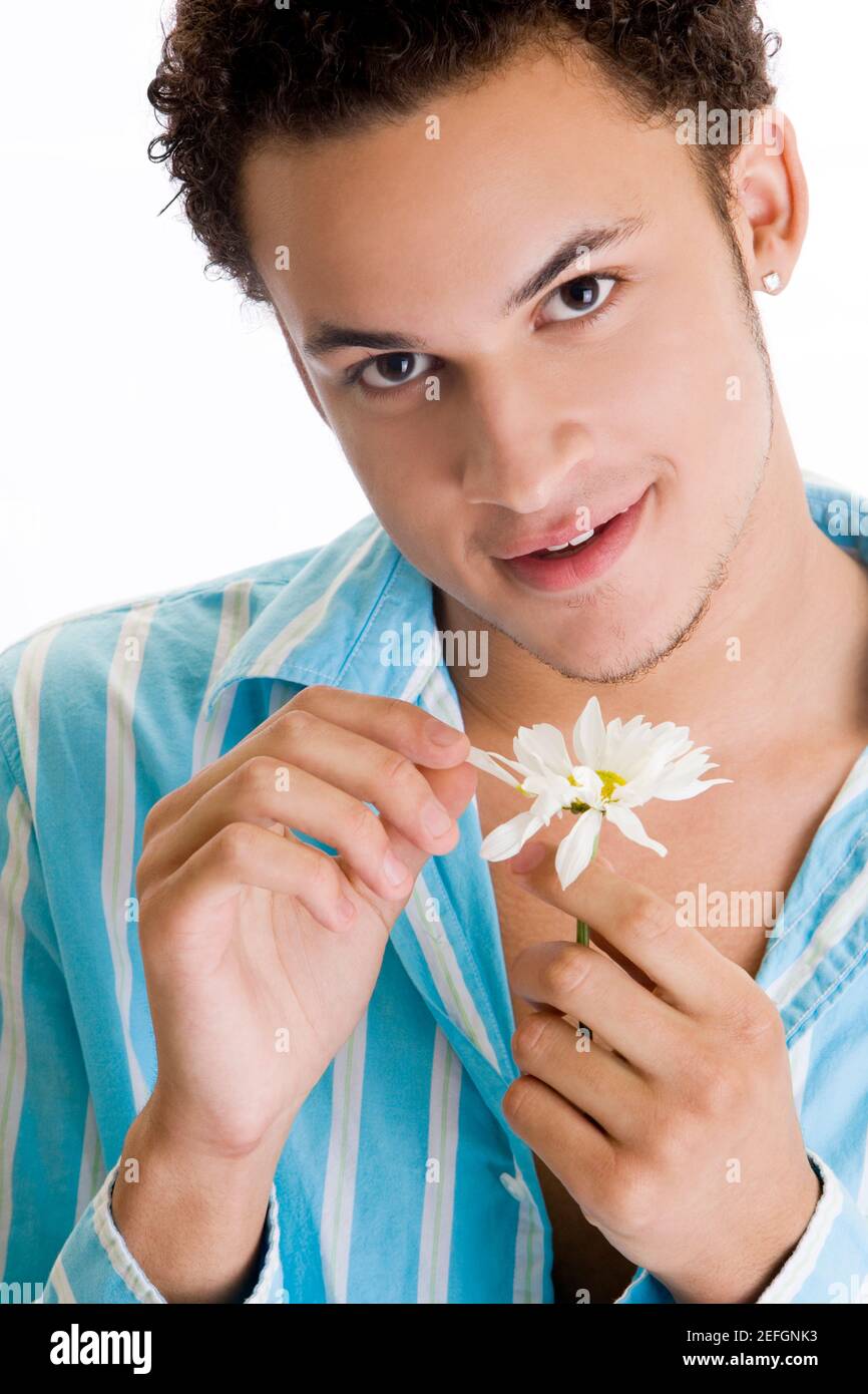 Ritratto di un giovane che raccoglie petali da un fiore Foto Stock