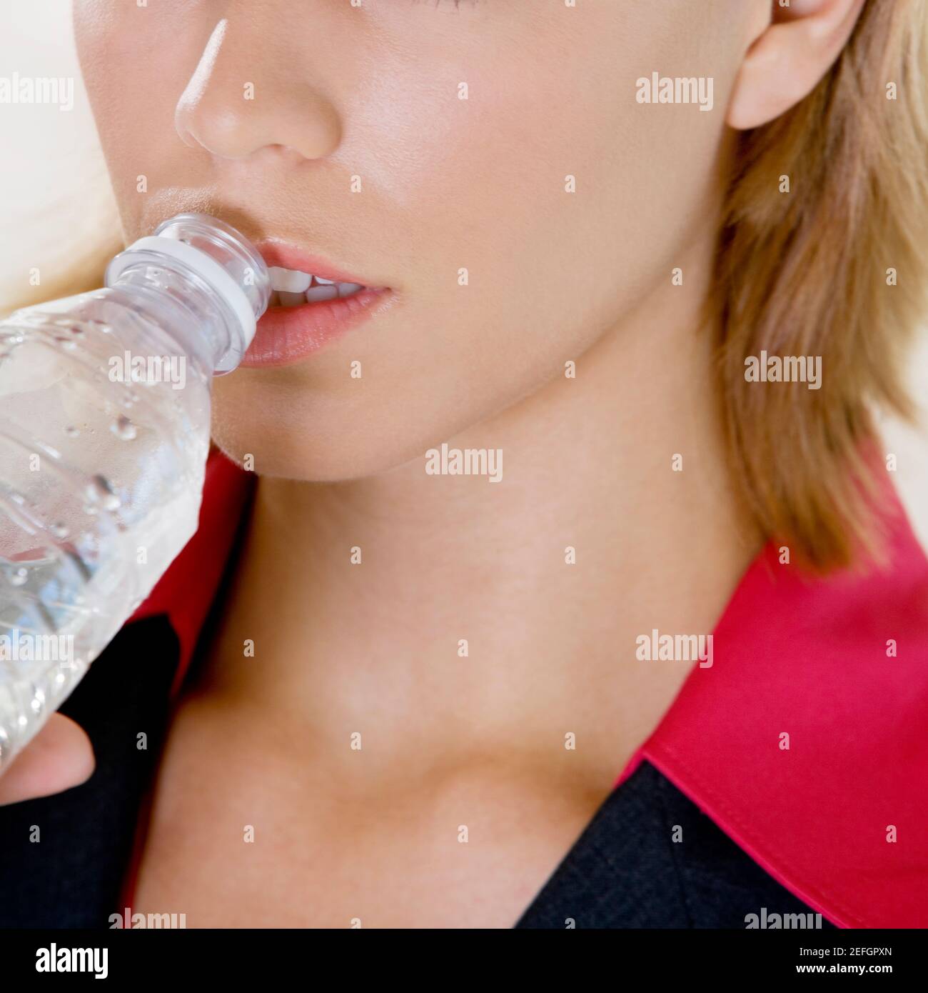 Close-up di una giovane donna di bere acqua da una bottiglia Foto Stock